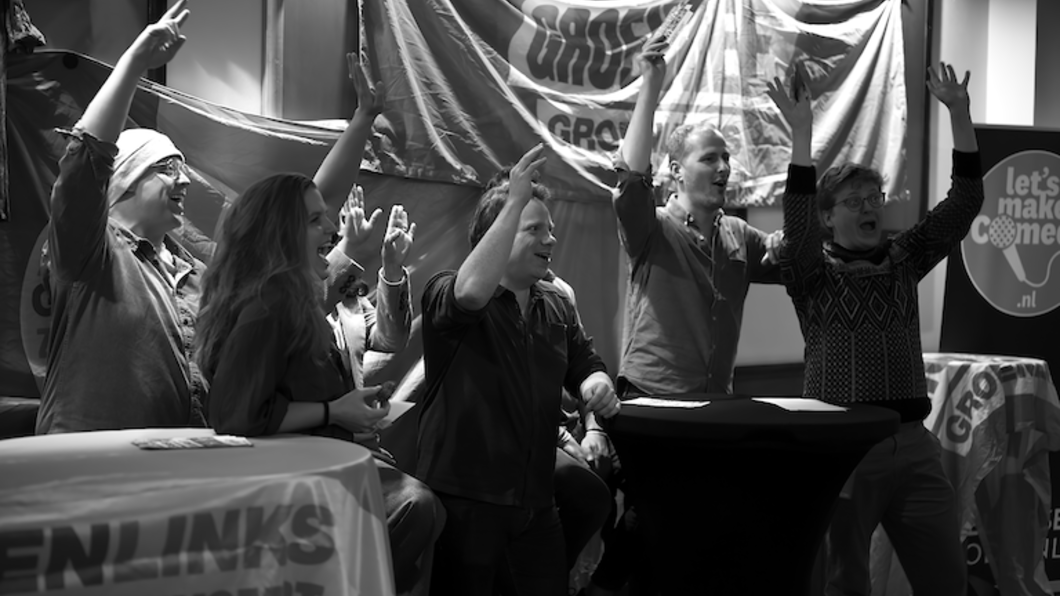 de fractie zingend met hun armen in de lucht